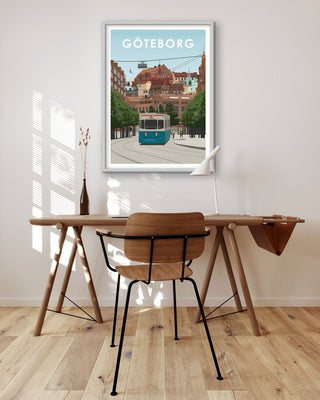 Tavla på väggen ovanför skrivbord med motiv från Göteborg. Spårvagn, hus.