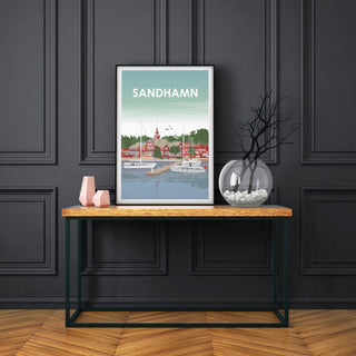 En poster över vackra Sandhamn. Segelbåtar ligger i hamnen och seglarhotellet i bakgrunden.